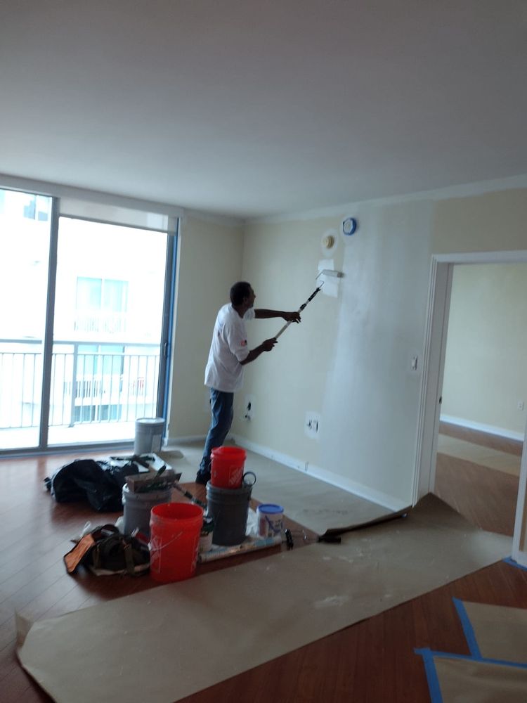 Home AMR worker painting an interior wall with a roller